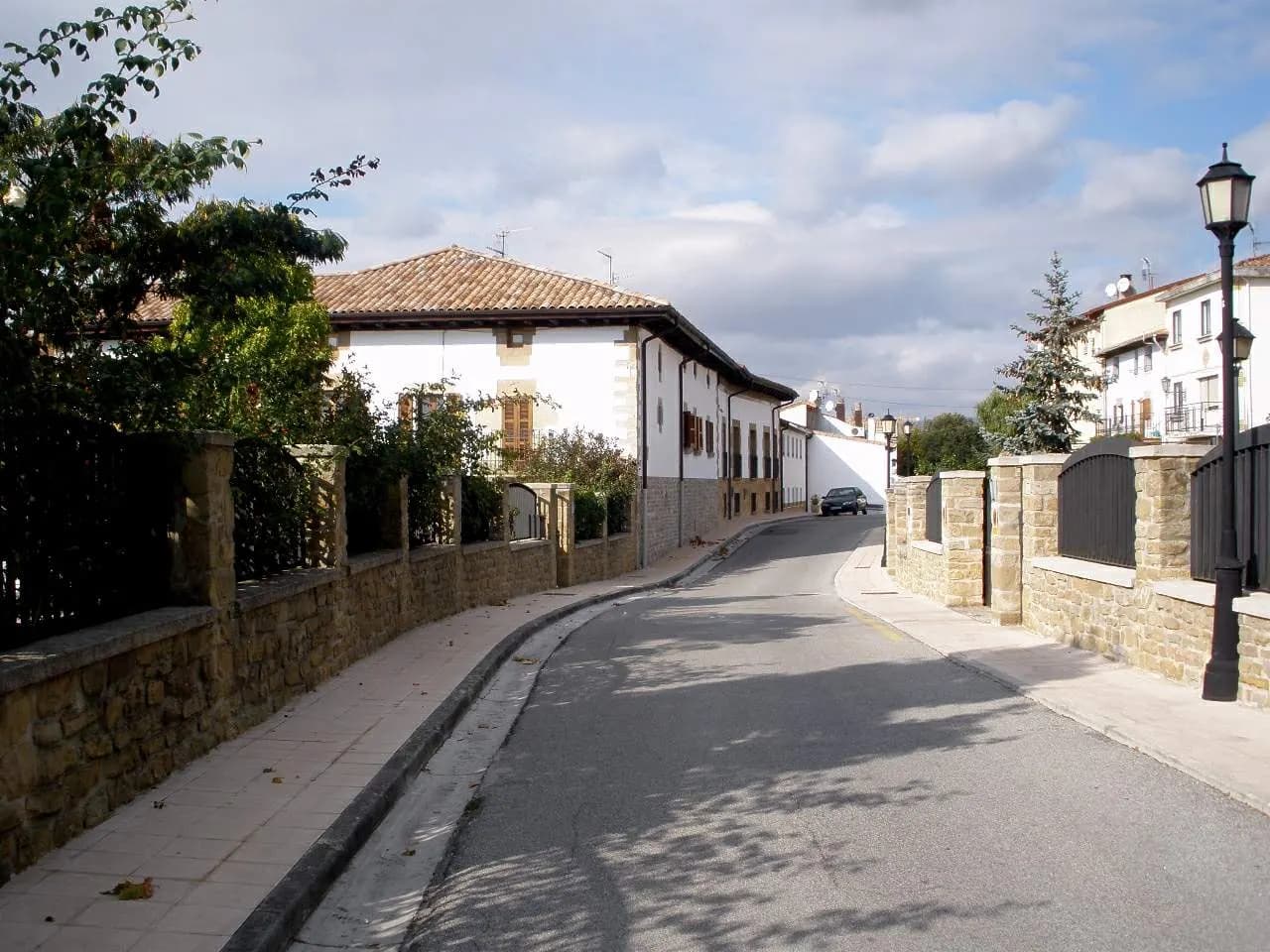 Calle del casco antiguo de Zizur Mayor con casas encaladas de tejado a cuatro aguas y muros de piedra