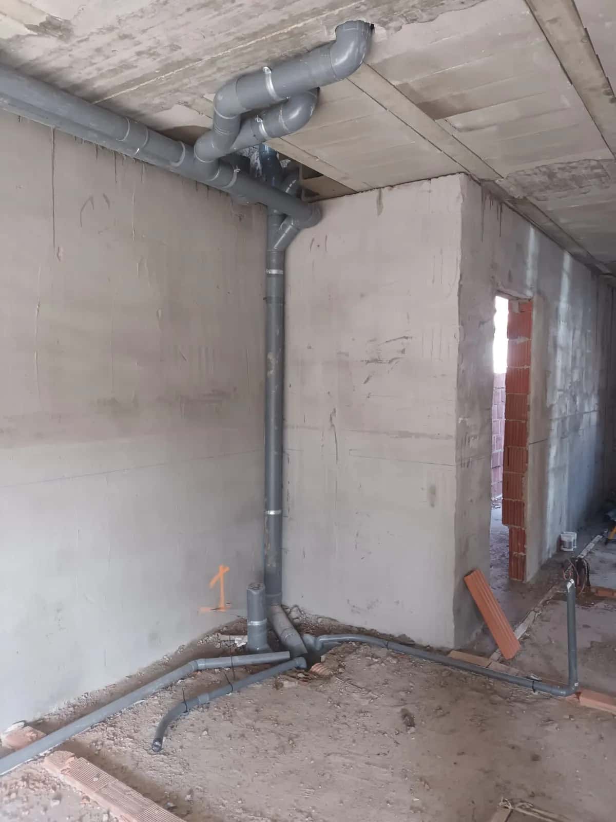 Bajante y colectores de PVC gris de saneamiento en una vivienda en construcción