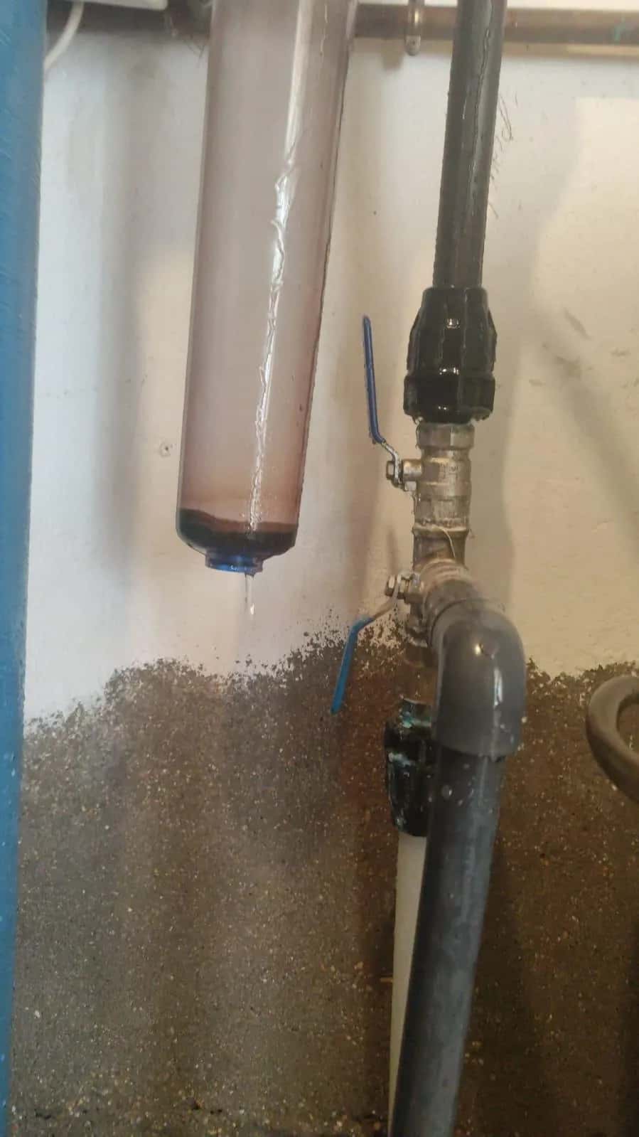 Filtro de agua con cartucho instalado en tubería de polietileno con llave de paso