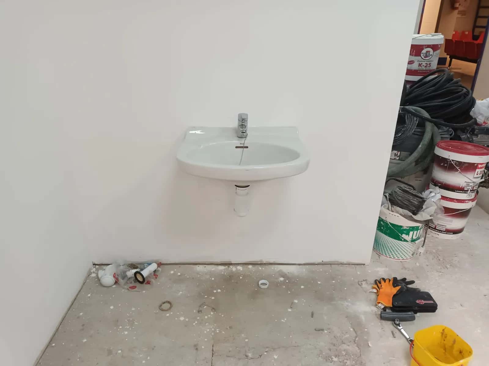 Lavabo pequeño recién colgado en una pared durante una obra